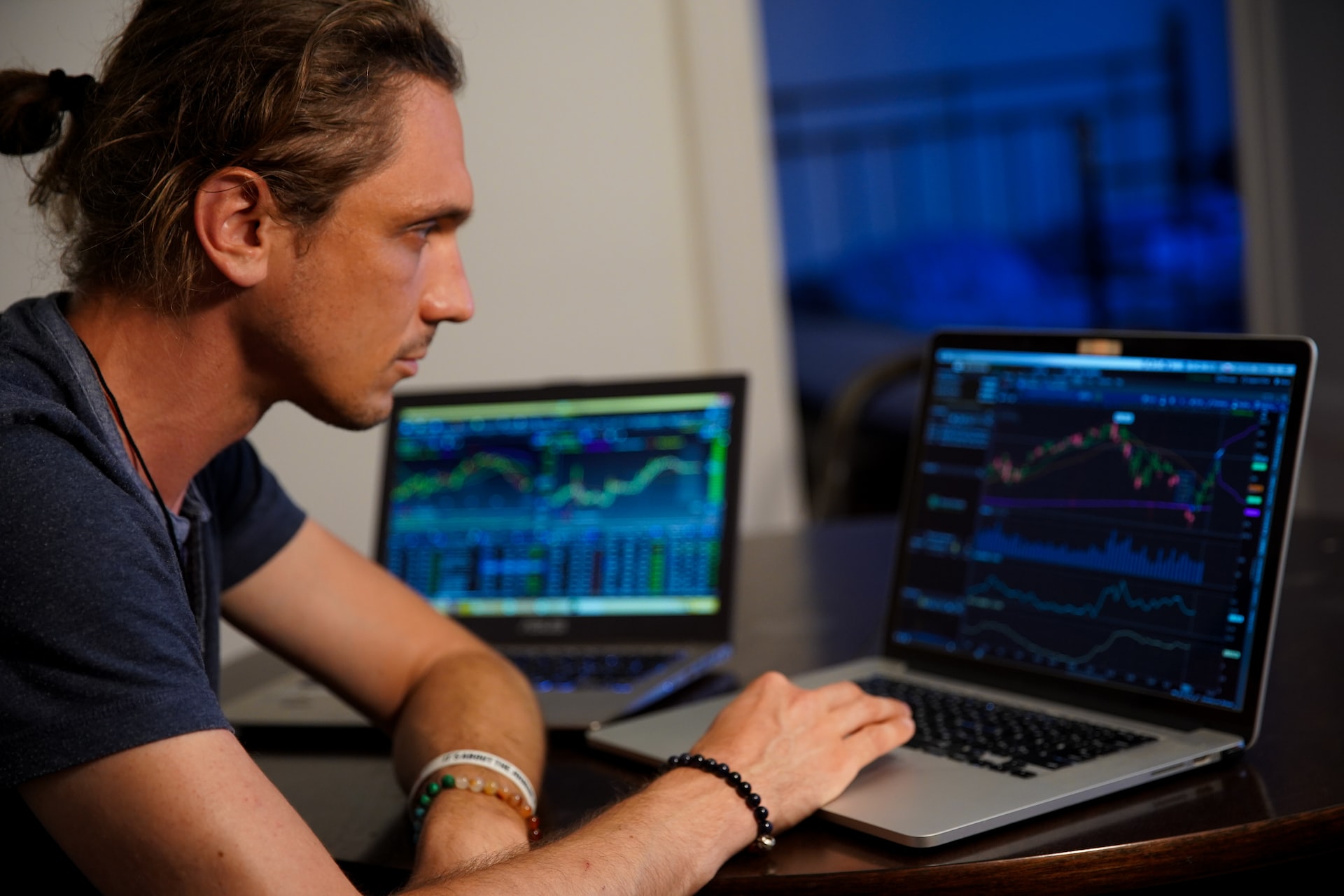 Our Mission man sitting in front of the MacBook Pro looking at charts